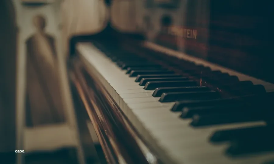 the keys of an upright piano in warm light